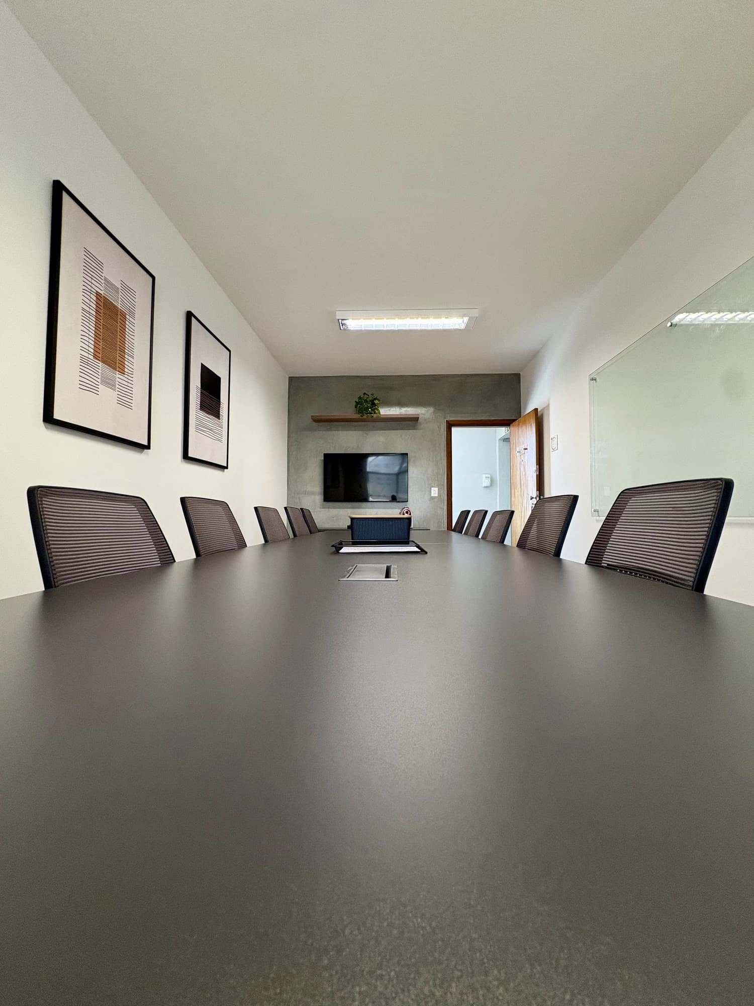 Sala de reunião em ângulo vertical com organizador sobre a mesa e porta ao fundo