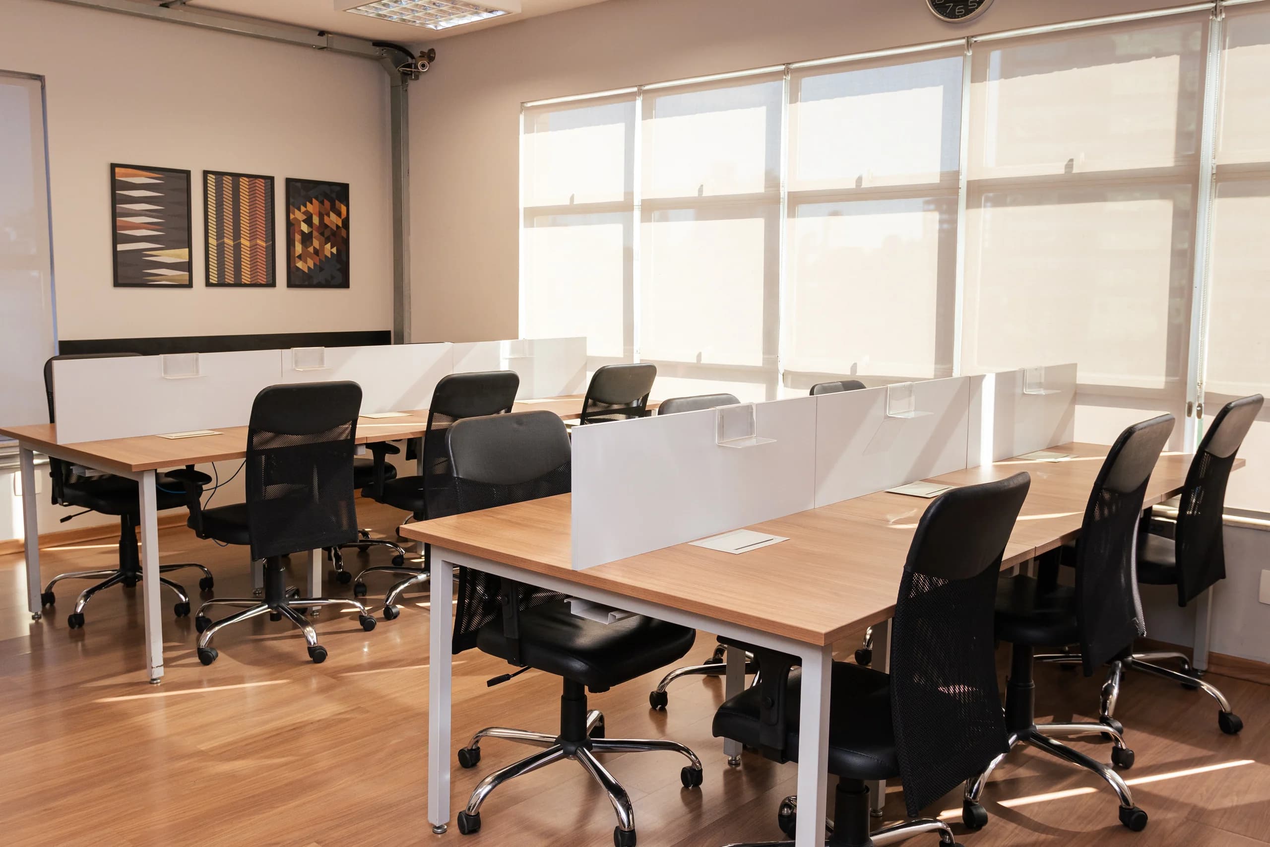 Fileiras de mesas e cadeiras ergonômicas no coworking Santa Efigênia