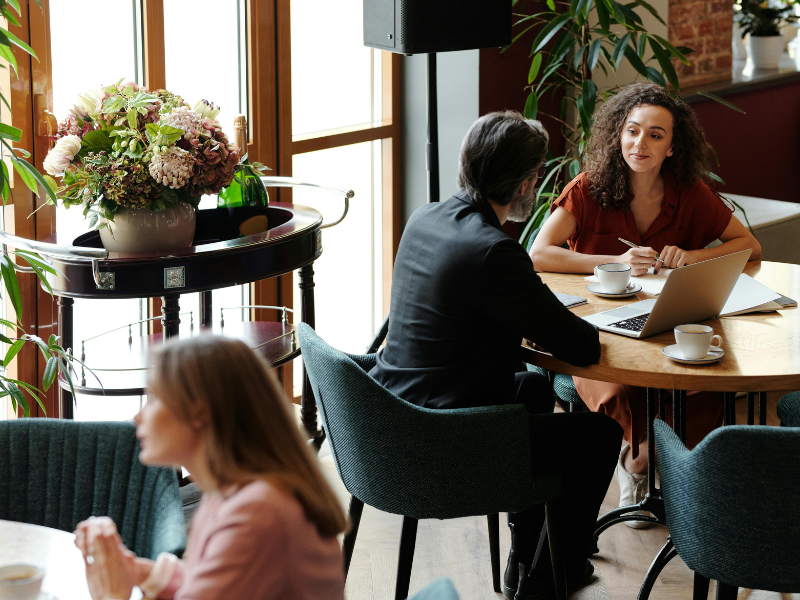 Duas mulheres trabalhando em coworking e tomando café em cafeteria